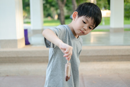 The face of an Asian boy standing and eating ice cream.の写真素材