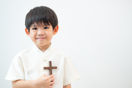 Little Asian boy praying with holding the cross, Christian conceptの写真素材