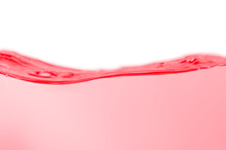 Red water surface with splashes and bubbles on white background.の写真素材