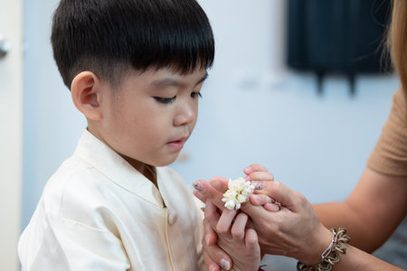 Little asian boy Giving a jasmine garland to mother On Thailand's National Mother's Dayの写真素材