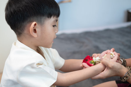 Little asian boy Giving a jasmine garland to mother On Thailand's National Mother's Dayの写真素材