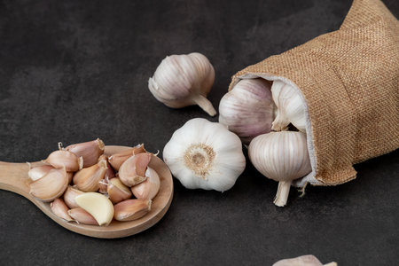 Big and small heads of garlic on a black background.の写真素材