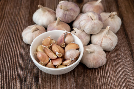 Big and small heads of garlic on a wood grain backgroundの写真素材