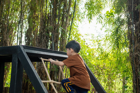 Little Asian boy playing children's sports equipment outdoorsの写真素材