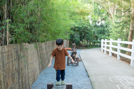 Little Asian boy playing children's sports equipment outdoorsの写真素材