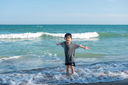 Little Asian boy showing happy expression on the sea beach