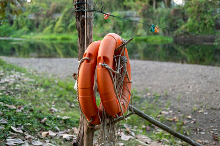 An orange lifebuoy hangs on a pole to prepare for the safety of people playing in the water.の写真素材