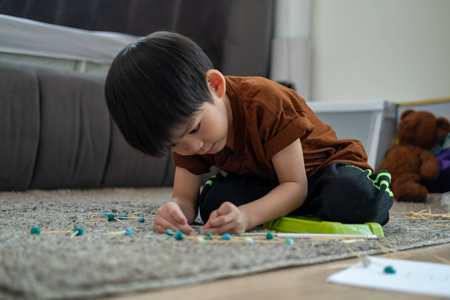 Asian boy playing with plasticine in the room