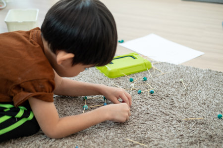 Asian boy playing with plasticine in the room