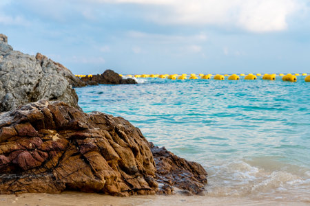 Beautiful views of the beach, sea, rocks during the day with buoys separating the swimming area.の写真素材