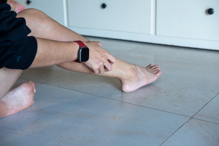 Man is scratching his leg due to itching.の写真素材