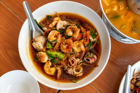 Spicy stir-fried seafood with chilli paste served on a white plate, a flavorful Thai dish