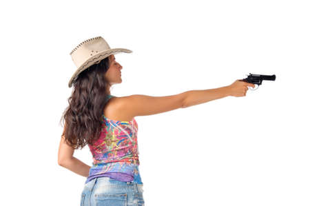 Young dark haired woman wear a hat aim a gun isolated on white backgroundの写真素材
