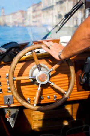 Standing at the wheel. Focus on male hand.