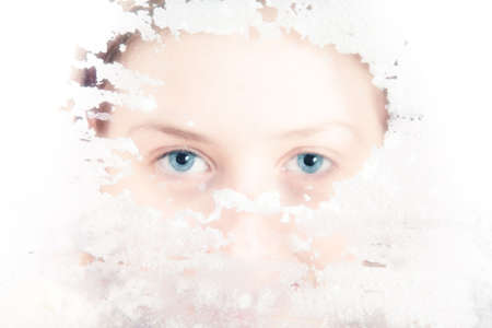Young woman looking through dirty glass. Bright white soft colors.の写真素材