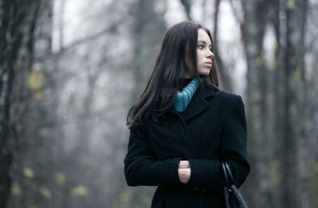 Lonely woman in a forest. Autumn november season.の写真素材