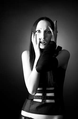 Scared goth woman portrait. On dark background.の写真素材