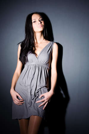 Young sexy woman on wall background. Contrast shadows.の写真素材