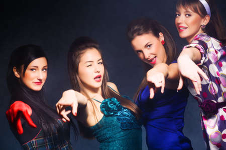 Cheerful party. Four women pointing to the camera.の写真素材