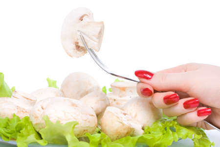 Woman hand holding fungi on a fork. Isolated on white.の写真素材