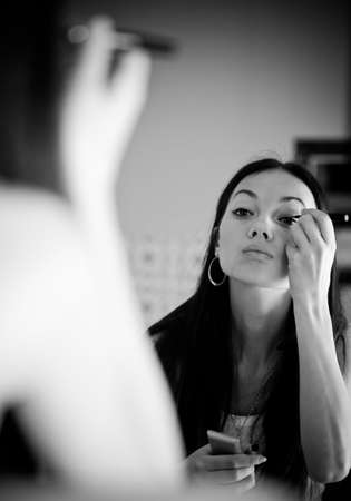 Young woman in front of mirror in make-up room. Black and white concept.の写真素材