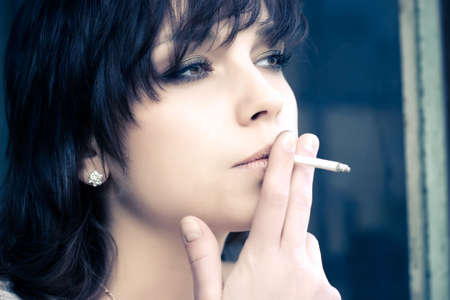 Smoking woman. Portrait in soft yellow and blue tint.