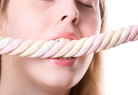 Young woman biting sweets. On white.
