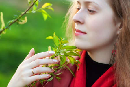 Young woman touching plant. Shallow dof.の写真素材