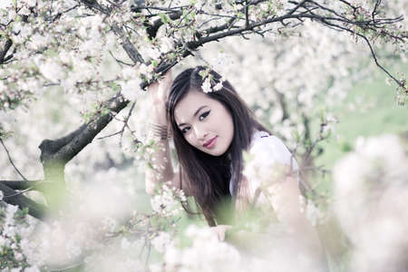 Young woman with cherry flowers portrait.の写真素材