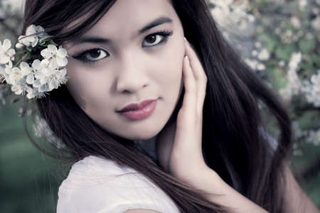 Young woman with cherry flowers. Shallow dof effect.の写真素材