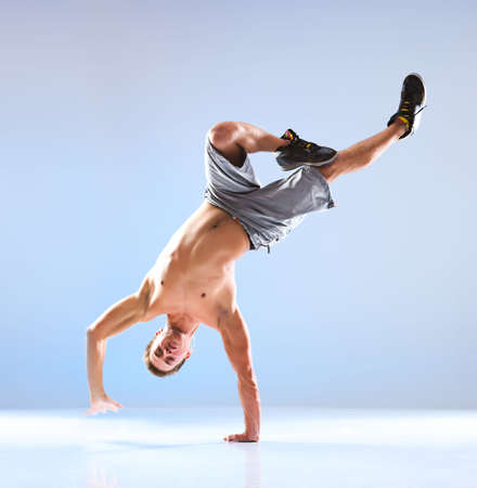 Young man modern dance. On soft white and blue background.