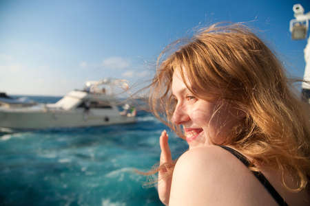 Young woman waving hand when leaving tropical island.の写真素材