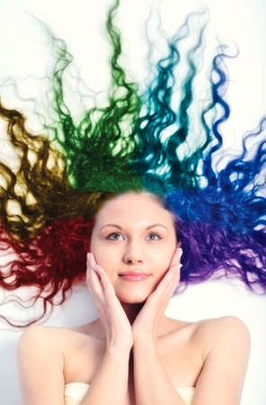 Young woman with long curly hair. Rainbow colored hair.