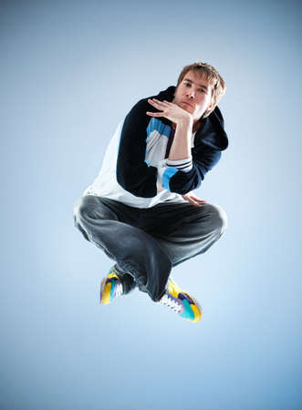 Young man modern dance. On soft blue background.