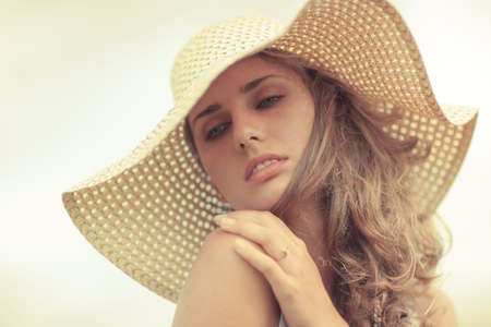 Young woman in a hat portrait. Yellow tint.