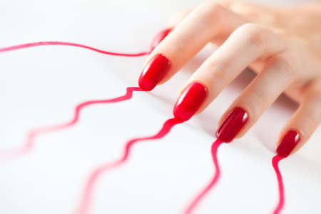 Young woman hand with red traces from nails. On white.の写真素材