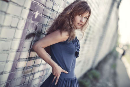 Young woman standing at the wall portrait.の写真素材