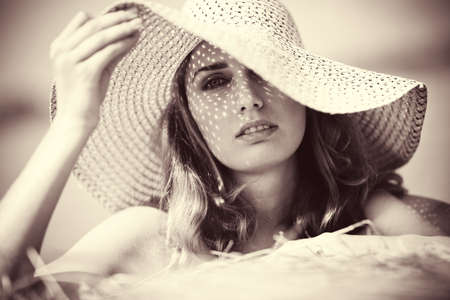 Young woman in a hat portrait. Soft yellow tint.の写真素材