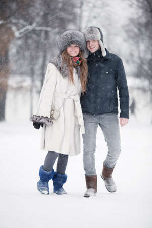 Young couple walking in a park. Winter season.