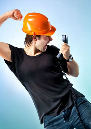 Workman screaming on phone. On soft blue background.