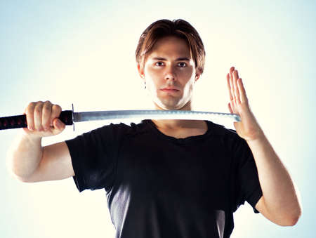 Strong man with samurai sword portrait.の写真素材