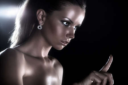 Young woman studio fashion portrait. On dark background.の写真素材