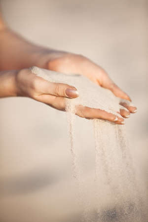 Young woman with sand in hands.の写真素材