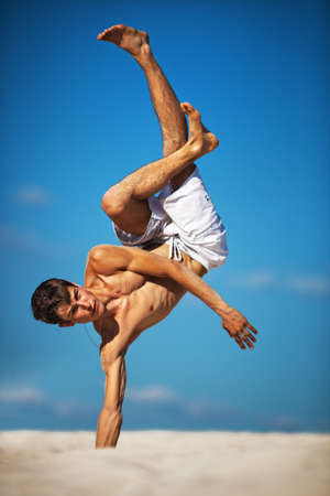 Young man dancing on beach.の写真素材