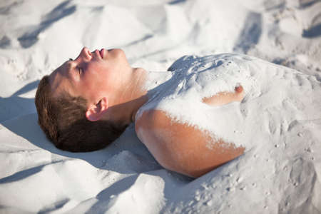 Young man buried in sand.の写真素材