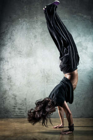 Young woman dancer. On wall background.