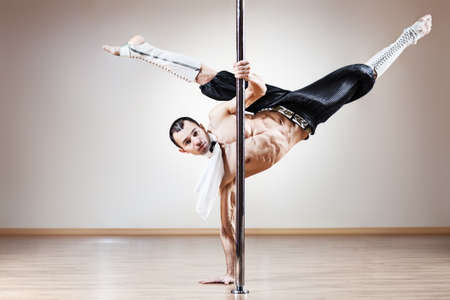 Young strong pole dance man.