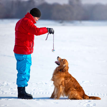 Young man playing with dog outdoors.の写真素材