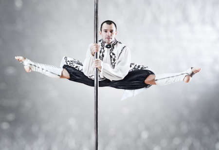 Young pole dance man. White colors.の写真素材