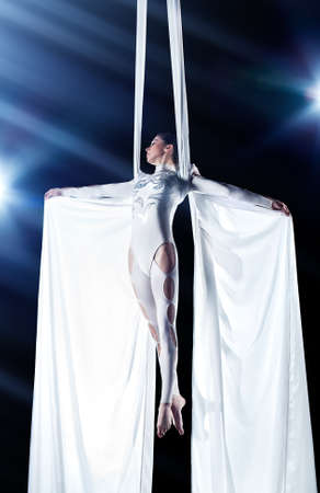 Young woman gymnast. On black background with flash effect.の写真素材